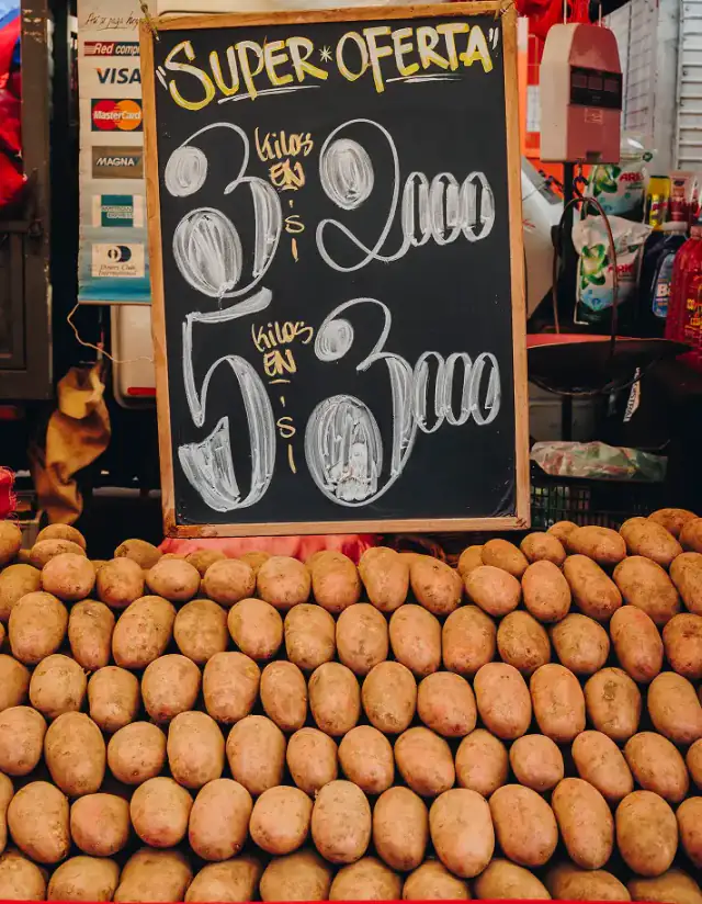 Cartel de oferta de papas por kilo en un puesto de feria